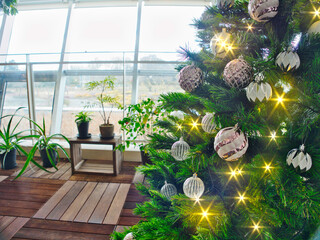 Twinkling Christmas tree lights with ornaments and  a bright window for background	
