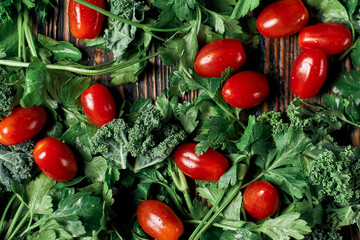 fresh tomatoes and sprigs of parsley on a wooden table.