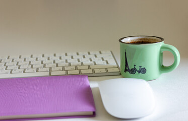 Cup of coffee with keyboard and notepad with pen