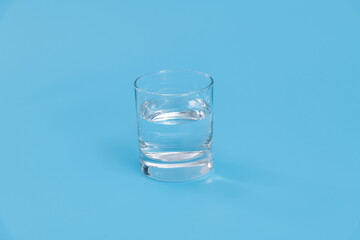 Glass of water on blue background