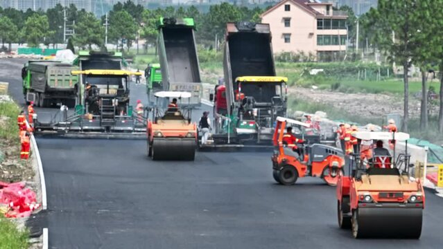 Construction site is laying new asphalt pavement, road construction workers and road construction machinery scene. Highway construction site scene. blurred work scene.