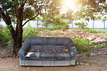 Old black sofa under the tree