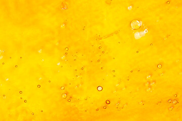 strong extract of gold cannabis wax with high thc close up, bubble shatter texture