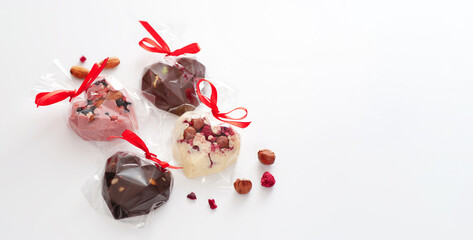 Chocolate candy in the form of hearts, homemade production, gift, on white background, banner, place for text