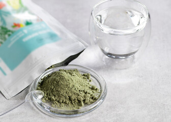 A source of biologically active substances, a food additive, herbal preparations, sprouted grains and vegetables, a superfood in dry form for adding to water and food, on a light background