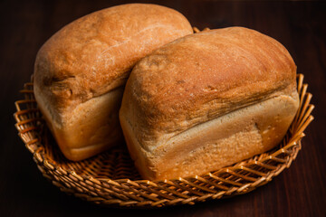 A loaf of bread on a wooden brown background.