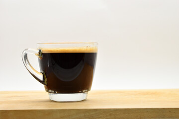 glass of black coffee put on wooden cutting board