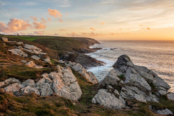 Stunning sunset landscape image of Cornwall cliff coastline with tin mines in background viewed from Pendeen Lighthouse headland