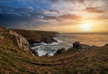 Fototapeta na wymiar Stunning sunset landscape image of Cornwall cliff coastline with tin mines in background viewed from Pendeen Lighthouse headland