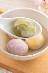 Colored glaze style big tangyuan with cherry blossom flower and syrup soup.