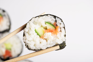 Sushi with chopsticks close-up on a white background