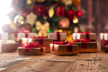 Christmas time. Christmas presents on rustic wooden table. Shallow depth of focus. Colorful bokeh lights.