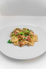 ravioli in an alfredo sauce with sun-dried tomatoes and parsley