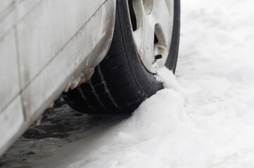Oblodzony samochód i opony zimowe, trudne warunki drogowe.
