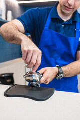 Fototapeta na wymiar Professional barista who prepares a coffee latte in his small business.