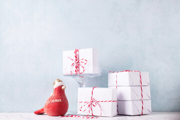 Postcard with  wrapped boxes with presents and ecorative red robin bird against  blue textured  wall. Scandinavian style. Place for text. - 554425733