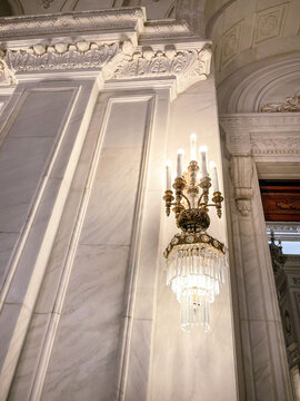 Bucharest, Romania - April 6, 2022: Bright crystal wall light on one of the halls inside Parliament Palace building, Romania. 