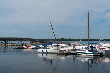 Fototapeta premium Big Lake Sentenberg. City harbour. Blue sky. Calm water. Lots of boats and yachts at the pier. A beautiful place to relax in nature near the water. Germany. . Without people