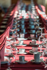 Large table prepared for a banquet, with plates, glasses and cutlery.