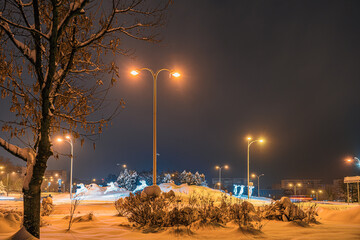 Mocno zasypane śniegiem droga i chodnik w mieście przemysłowym na Śląsku w Polsce, Jastrzębie-Zdrój nocą. - obrazy, fototapety, plakaty