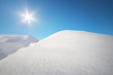 Snow hills and deep blue sunny sky.
