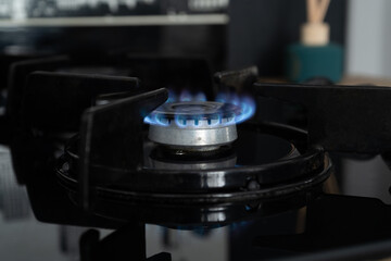 Cooking gas stove burning blue flame. Lit gas ring on a cooktop. Cooker hob in the kitchen.