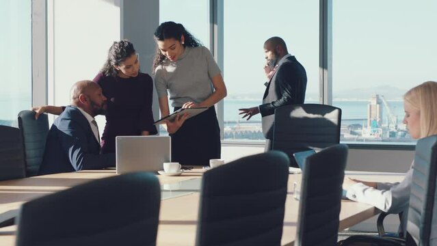 Business people, meeting and corporate planning with tablet for discussion while talking about SEO, benchmarking and kpi research report. Men and women in office for growth development strategy