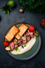 Vitello tonnato, sliced tuna, capers, tomatoes, sauce, fried toast.