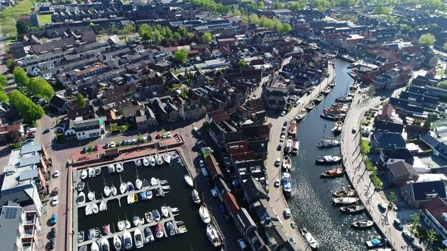 Aerial view of Spakenburg marina and old port in background showing vintage wooden sailing boats called skutsjes and building left and right of the harbor it used to be a fishing harbour in the past