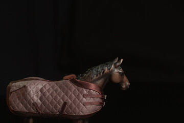 Black toy horse isolated on black background