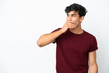 Young Argentinian man isolated on white background doing surprise gesture while looking to the side