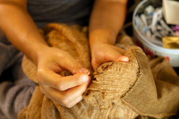 Sew clothes with a needle, mens hands. Sewing and fashionable needlework. Selective focus - obrazy, fototapety, plakaty