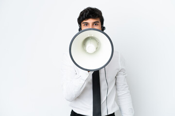 Telemarketer man working with a headset isolated on white background shouting through a megaphone