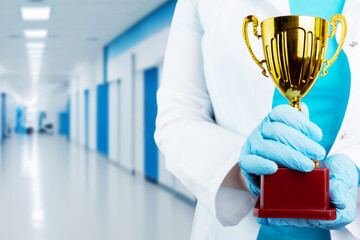 doctor holds a cup in his hands on hospital background, a professional medical award