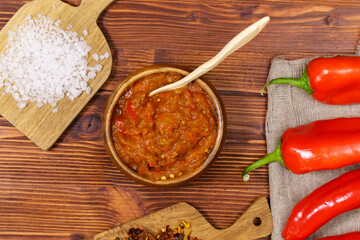 Ajvar delicious dish of red peppers and eggplant. Waiting for tasting. Wooden background