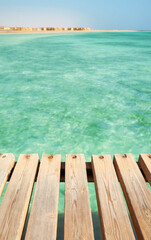 Fototapeta premium Wooden pier boards at a sea, selective focus, copy space.