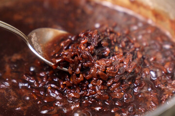 Cooking brown rice in water close-up. Organic natural ingredients for a healthy diet. Selective focus.