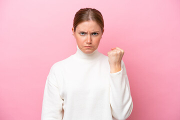 Young caucasian woman isolated on pink background with unhappy expression