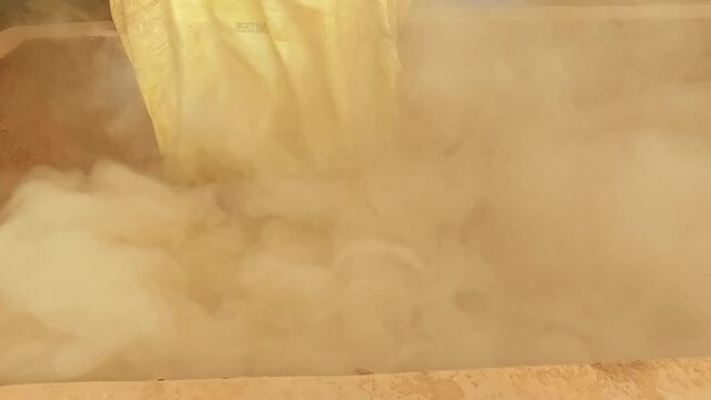 Worker pouring incense powder into big mixing machine