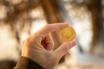 Bitcoin Coin in man hand on a snowy day Crypto winter