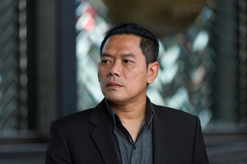 Fototapeta premium Closeup of headshot Asian business man wear suit standing in the office