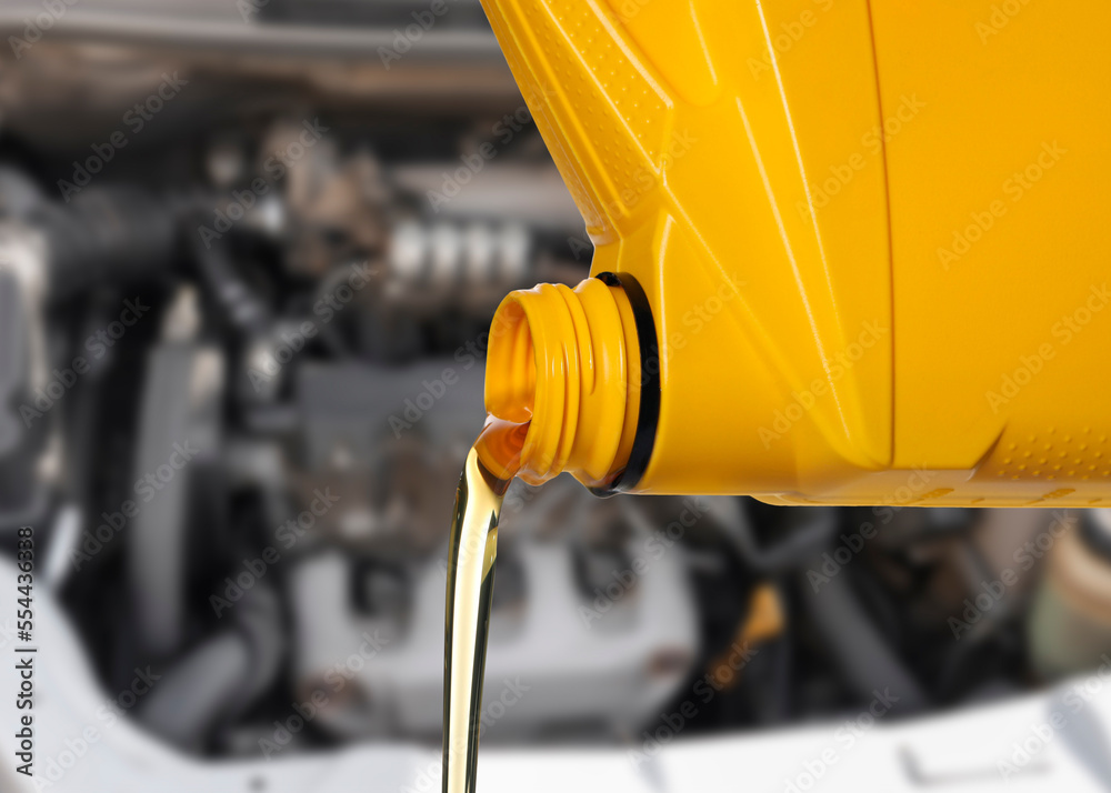 Wall mural pouring motor oil from yellow container, closeup