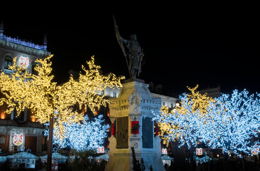 Fotografía nocturna de la estatua del conde Ansúrez, fundador de la ciudad de Valladolid, rodeado de luces de navidad en diciembre, España