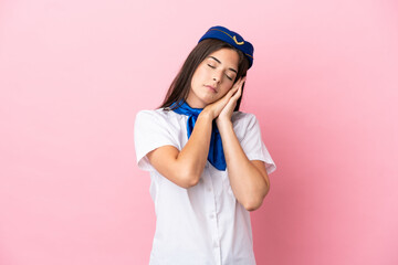 Airplane stewardess Brazilian woman isolated on pink background making sleep gesture in dorable expression