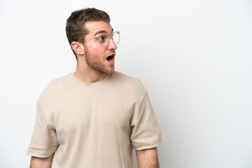 Fototapeta premium Young caucasian man isolated on white background doing surprise gesture while looking to the side