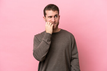 Young caucasian man isolated on pink background is a little bit nervous
