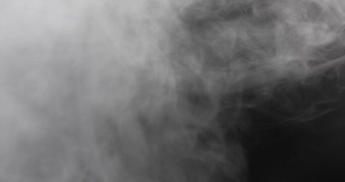 Smoke on black background. Neutral coloured white smoke / fog on a black neutral background. Different variations of fog formations in DCI 4K