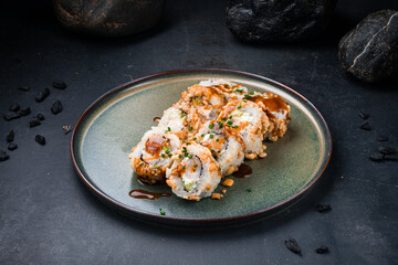 Sushi rolls set with shrimp, Philadelphia cheese, avocado, cashews, teriyaki sauce with caramel on a plate.