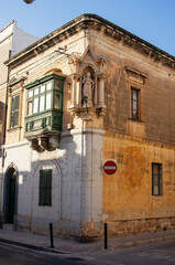 Obraz premium Corner house constructed of limestone with statue of Jesus, Mosta, Malta