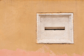 Blank marble letterbox on the facade of a historic Italian building